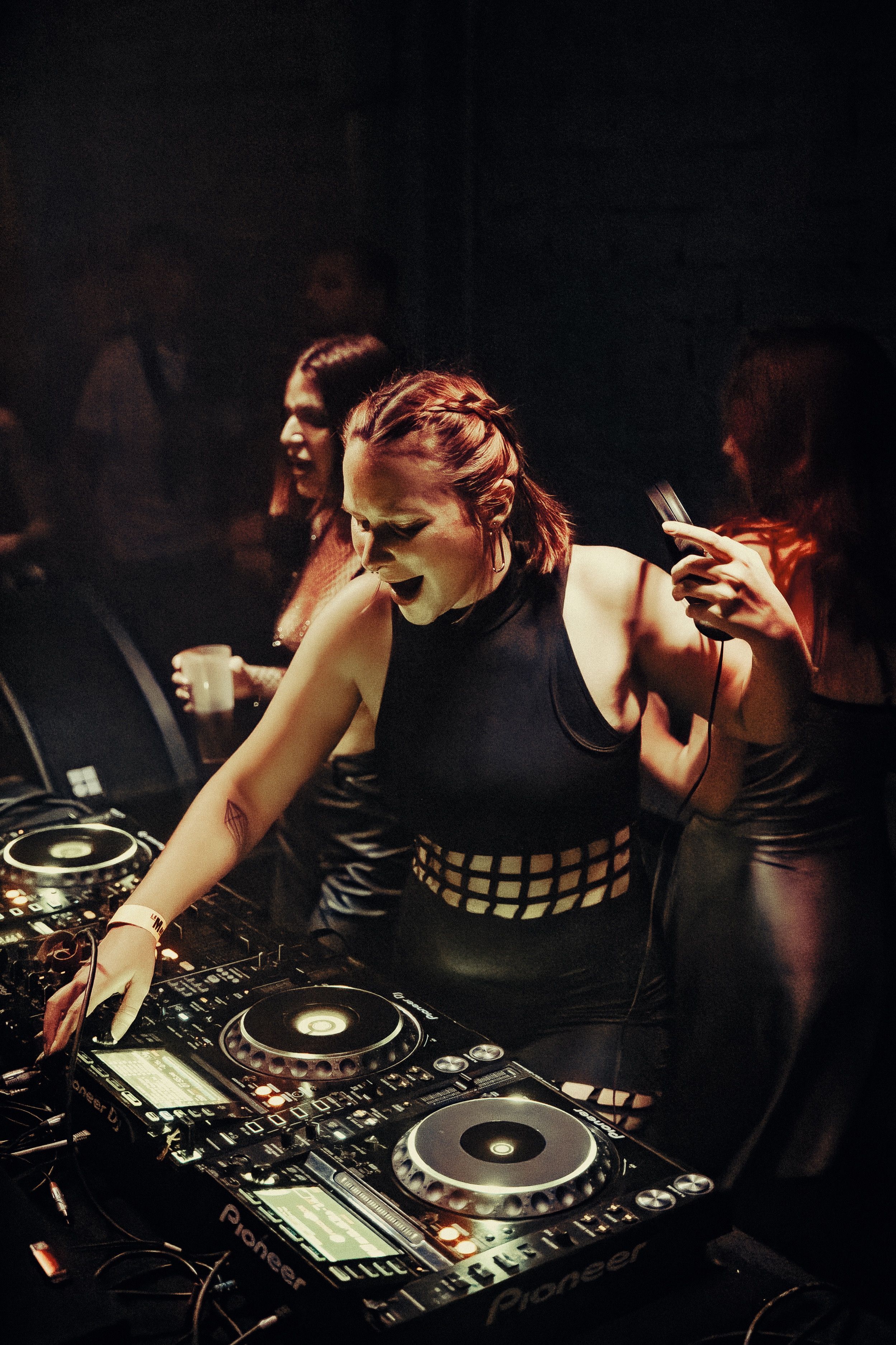 Photographie de Louise Pétrouchka devant ses platines, en train de mixer de la musique